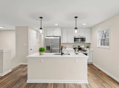 Bright modern kitchen with island, white cabinets, and pendant lights by Beiler & Co in Winchester VA